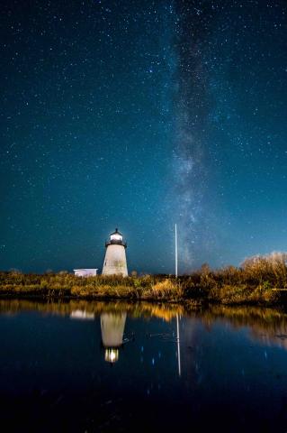 reflection of the lighthouse in calm water