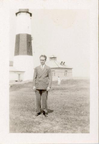man poses in front of tower