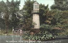 people stand on dock behind lighthouse