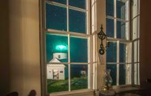 view of lighthouse at night out keeper's dwelling window