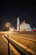 light trails from car pass lighthouse