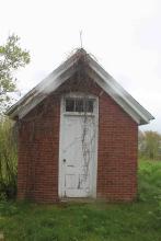oil house over grown dead vines hang off it